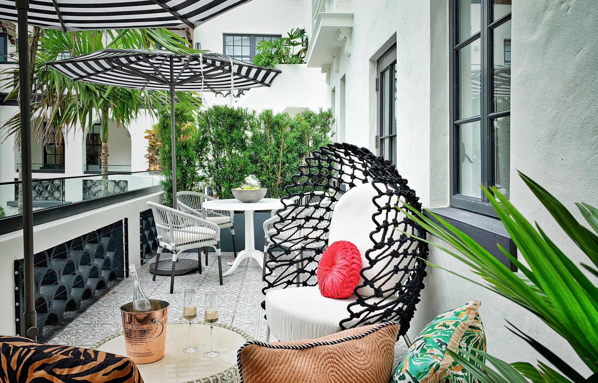 A guest room's outdoor space that faces the courtyard features historic walls with scalloped details and the discrete glass additions to the top that bring them up to code