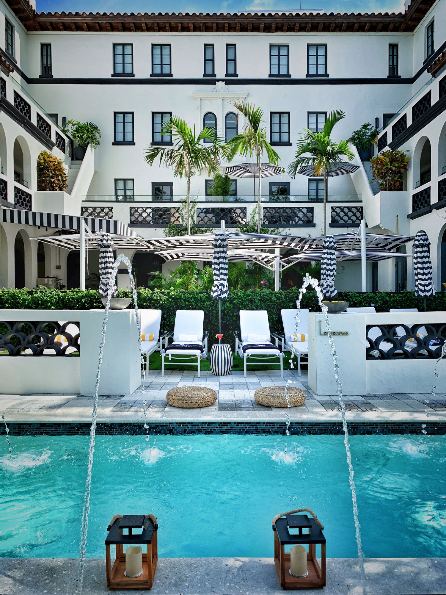 new pool in the courtyard of White Elephant Palm Beach incorporates two historic wing walls as privacy screens for sunbathers