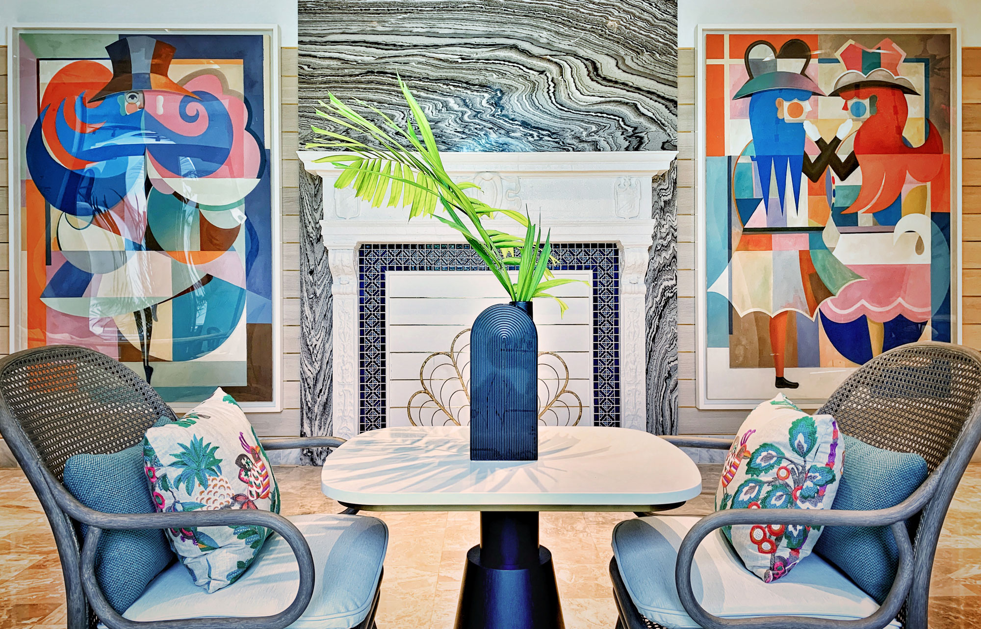 Breakfast area in the gallery of White Elephant Palm Beach with artwork by Bernhard Buhmann flanking a historic fireplace